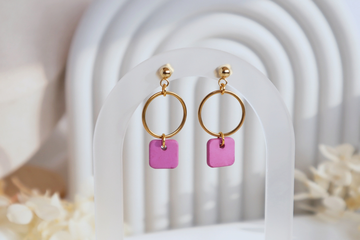 Kleine Hängeohrringe aus 304 Edelstahl in der Farbe Gold mit einem Pinken eckigen Anhänger aus Beton der an einem Ring hängt..
Hypoallergene Kugelohrstecker. Gesamtlänge ca. 3,3 cm. ein Ohrring wiegt unter einem Gramm