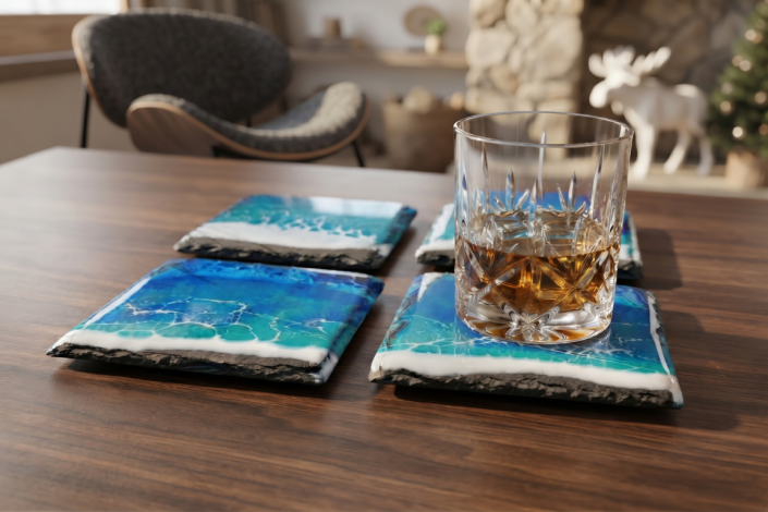 4 Schieferuntersetzer mit Meereseffekt aus Epoxidharz auf einem Holztisch. Auf einem der Untersetzer steht ein Whiskeyglas. Im Hintergrund ist ein moderner Sessel zu sehen, ein weißer Elch und ein angedeuteter Weihnachtsbaum