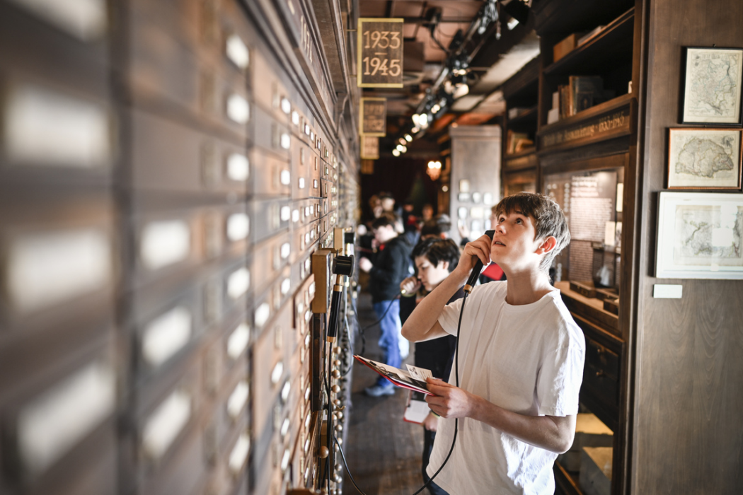 Besucher:innen folgen einer von 18 echten Biographien durch die multimediale Ausstellung. © Deutsches Auswandererhaus / Foto: Karsten Klama
