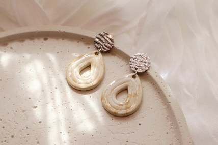 Ohrringe mit einem Tropfenförmigen Anhänger.
Stecker aus 304 Edelstahl in der Farbe Silber. Anhänger aus Beton in Braun/ Beige, vorne und Hinten mit Epoxidharz veredelt.
Gesamtlänge ca. 4 cm, ein Ohrring wiegt ca. 4 Gramm