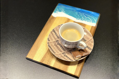 Brett mit Meereswellen und Espressotasse