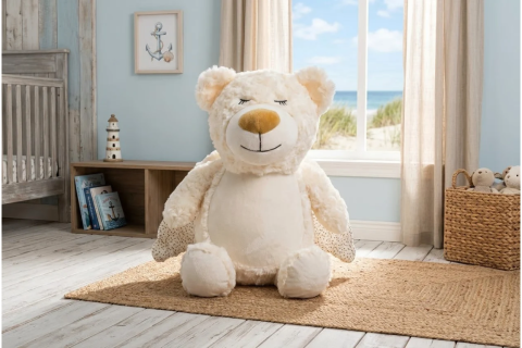 Teddy Kuscheltier in Beige sitzend auf Teppich in Kinderzimmer.