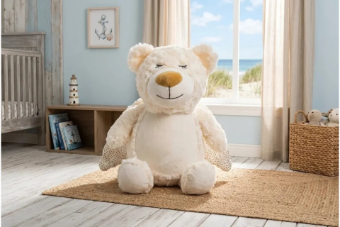 Teddy Kuscheltier in Beige sitzend auf Teppich in Kinderzimmer.