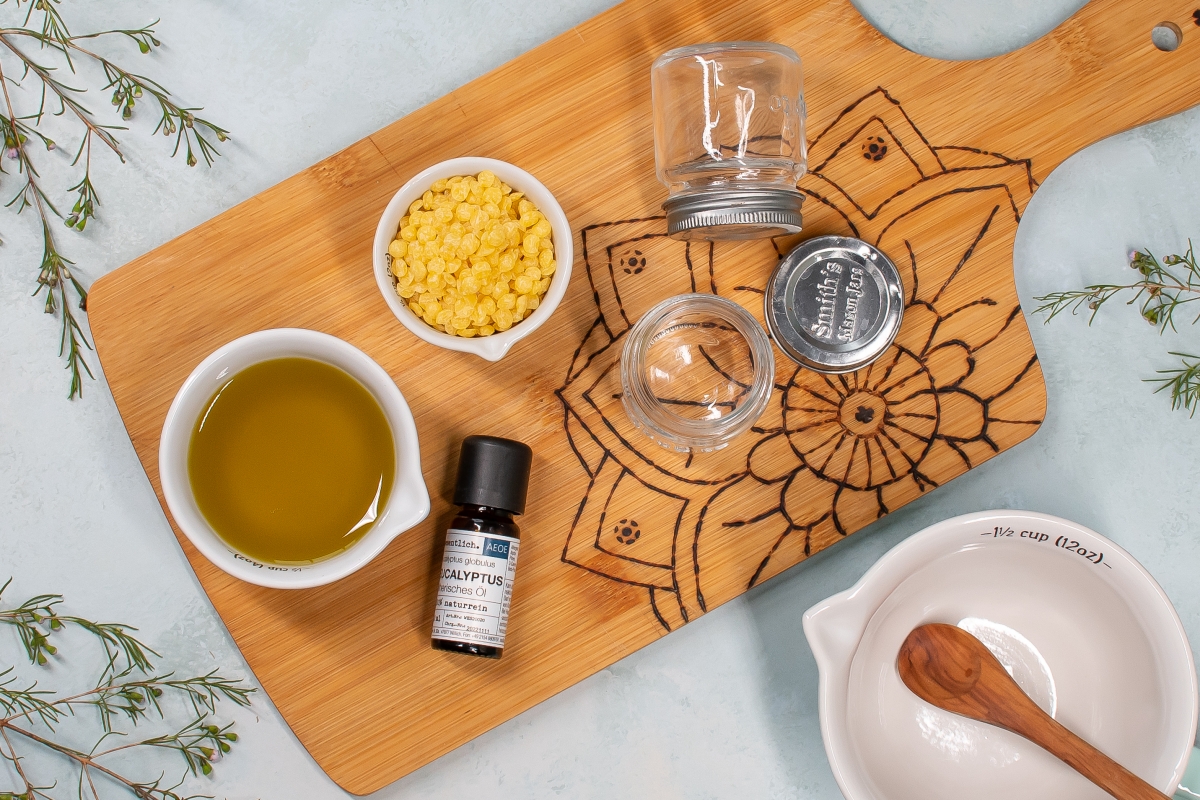 Zutaten zur Herstellung von Erk&auml;ltungsbalsam liegen auf einem Brettchen.