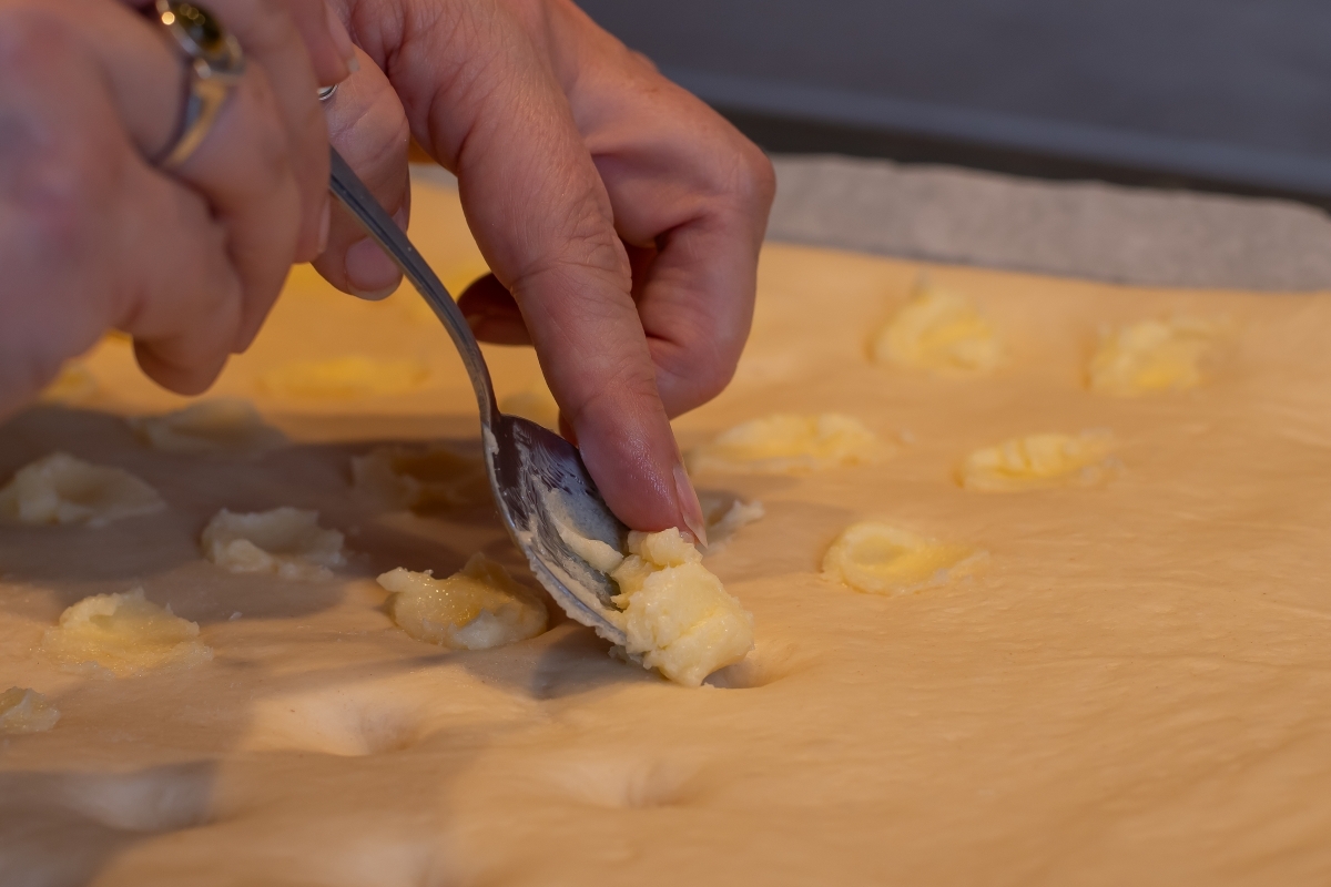 Ein Löffel sticht Teile aus dem Teig aus. 