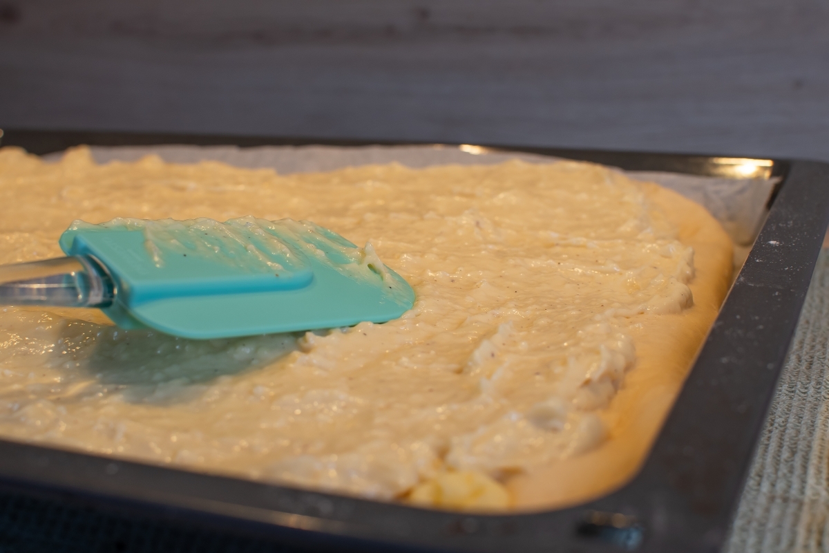 Pudding wird auf einem Kuchenteig verteilt.