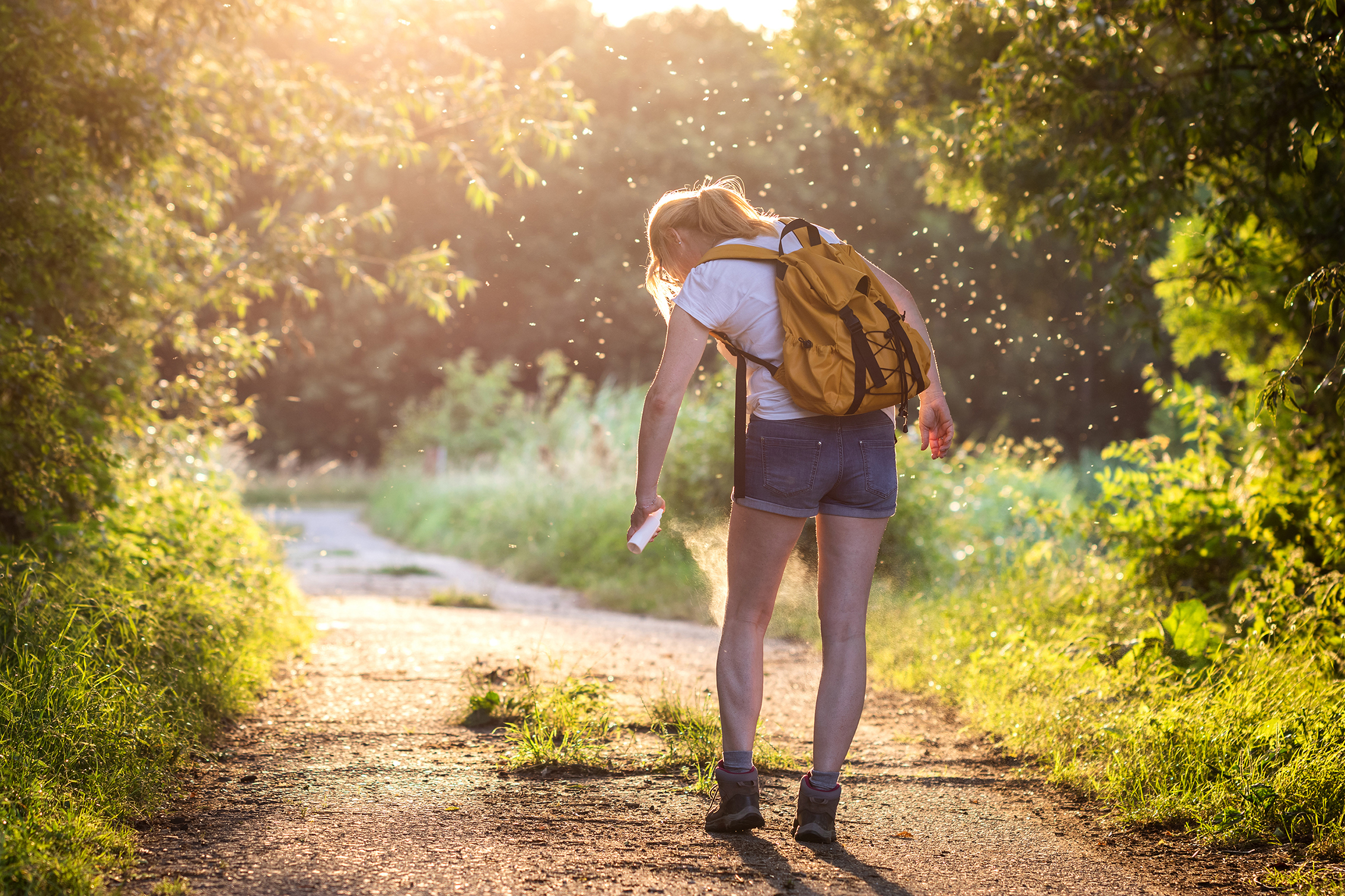 Wanderin im Wald mit Mückenspray - einfach Heimat